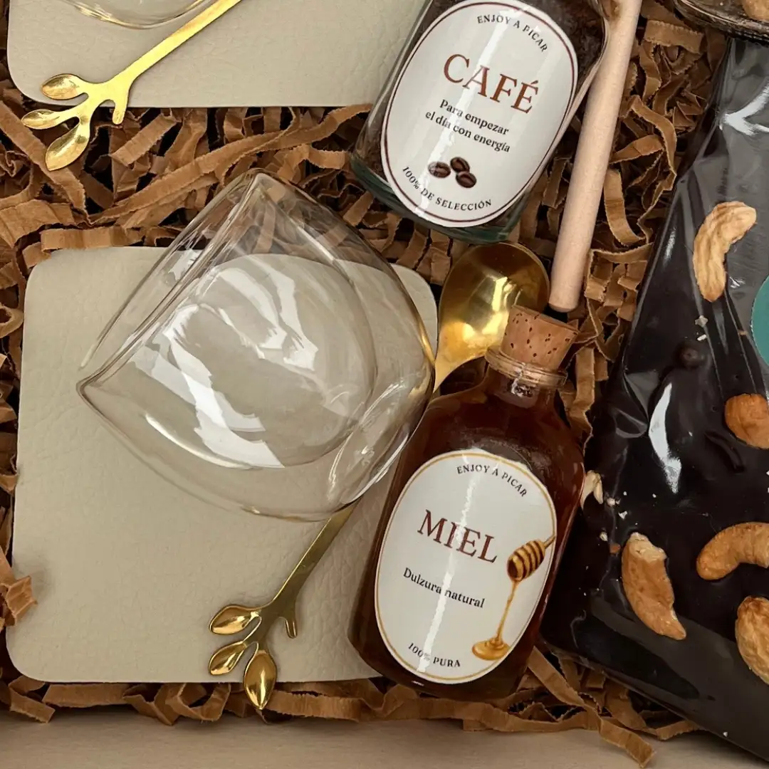 Detalle de taza de cristal, frasquitos de vidrio con corcho para café e infusiones y miel pura con cuchara de madera.