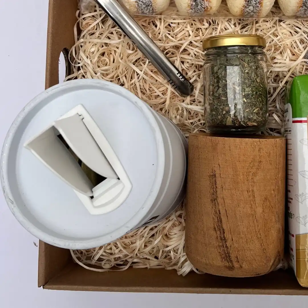Detalle de mate de madera y lata yerbera metálica con pico vertedor.