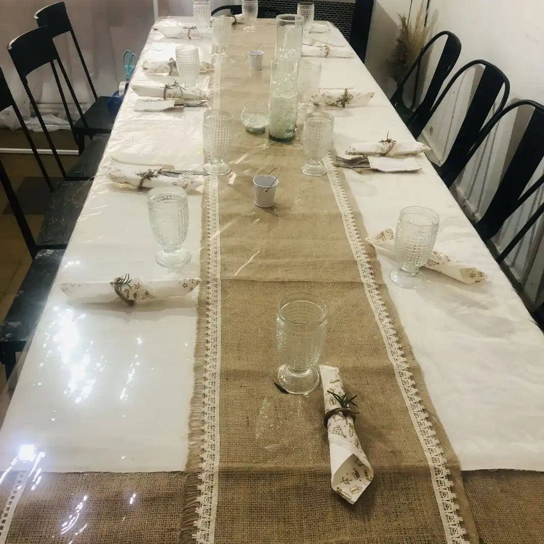 Mesa de comensales armada con plato principal, copa de vidrio y servilleta para banquete.